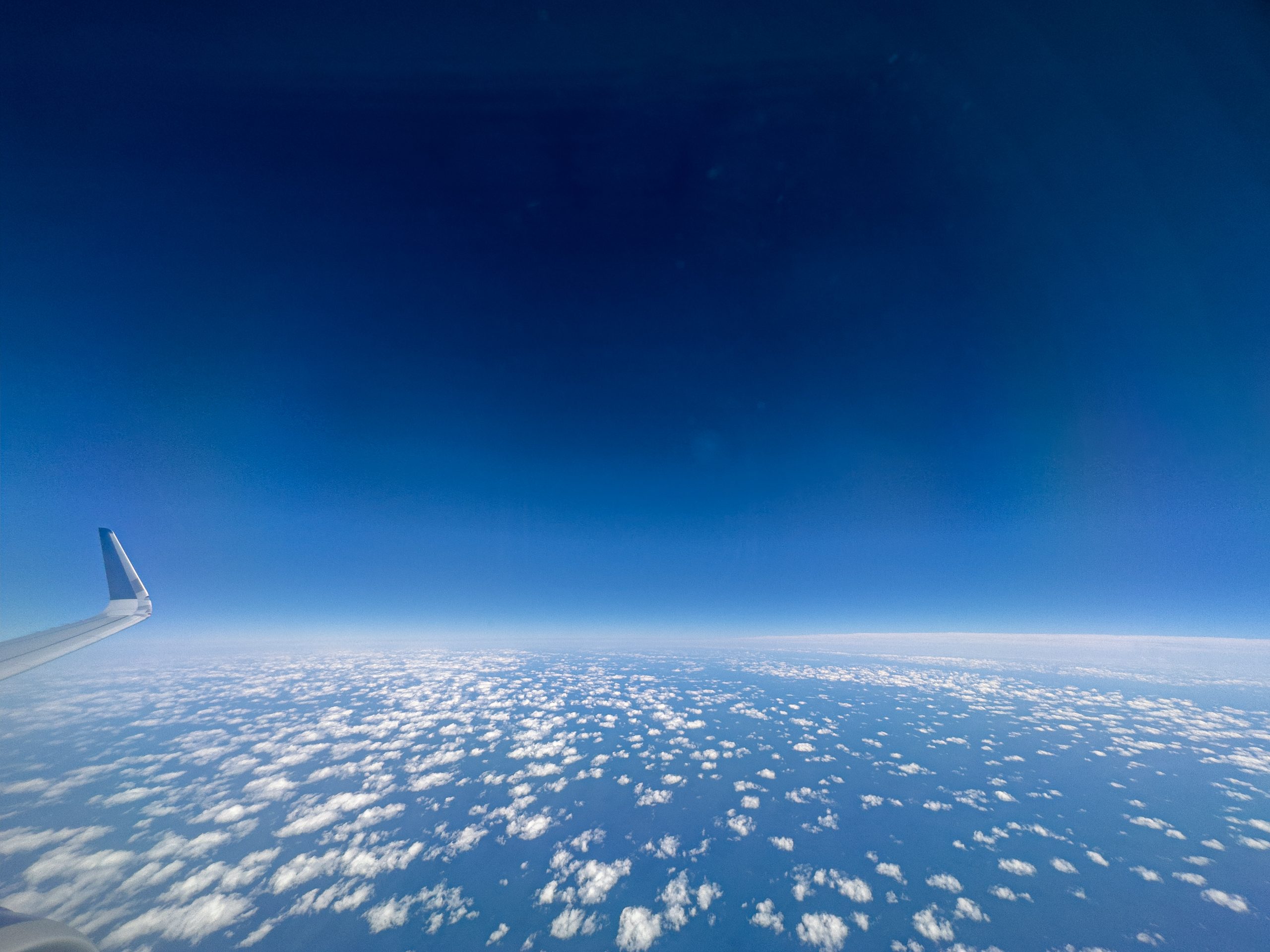 Deep blue sky and small puffy clouds at 30,000 feet